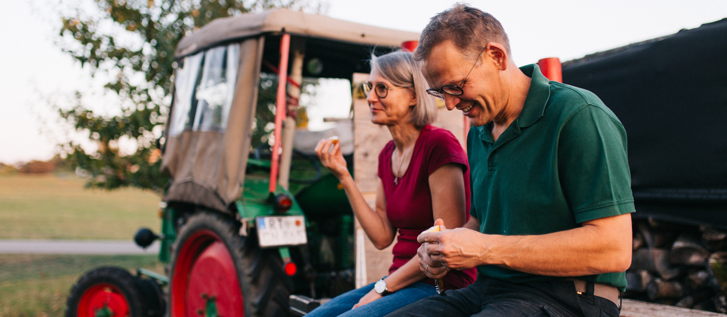 Herr und Frau Weiss machen Pause auf einem Traktor