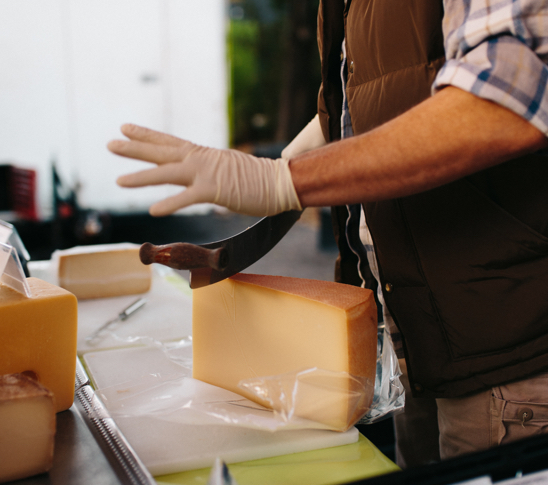 Hand schneidet Käse